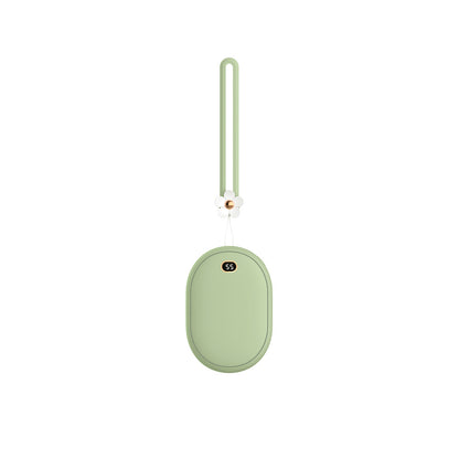 Mini sage green power bank/hand warmer, oval-shaped, with a digital display (55) and a flower charm on the lanyard.