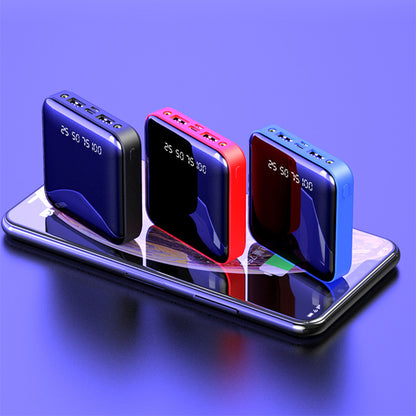 Three mini portable power banks (dark blue, red, blue) with mirrored digital displays, shown resting on a smartphone.