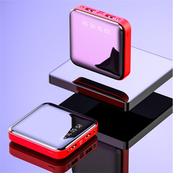 Two square, red-framed mini power banks with mirrored digital displays showing charge percentages, staged on reflective blocks.