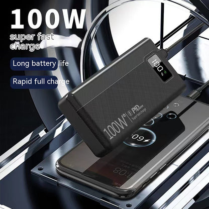 Black, textured 100W power bank displaying 100% charge, resting on and charging a smartphone.