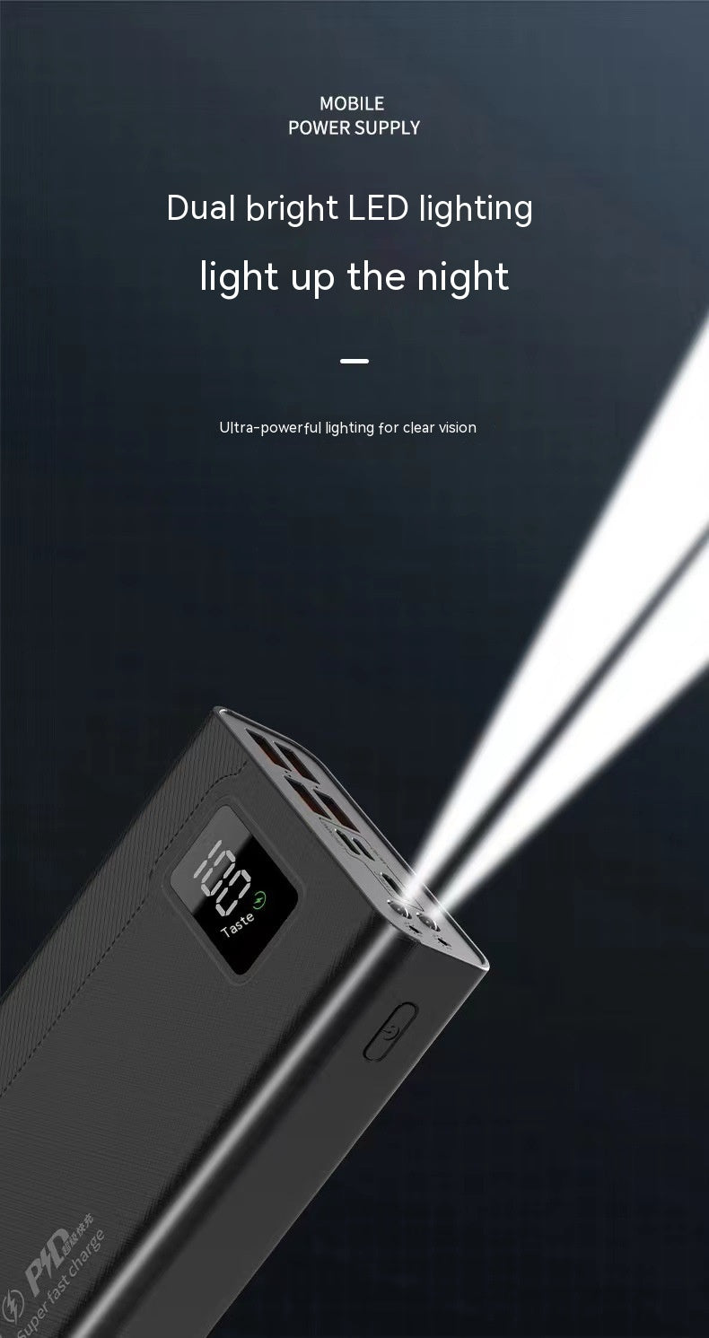 A black power bank with a digital display showing 100%, featuring dual bright LED lights illuminating the dark background.