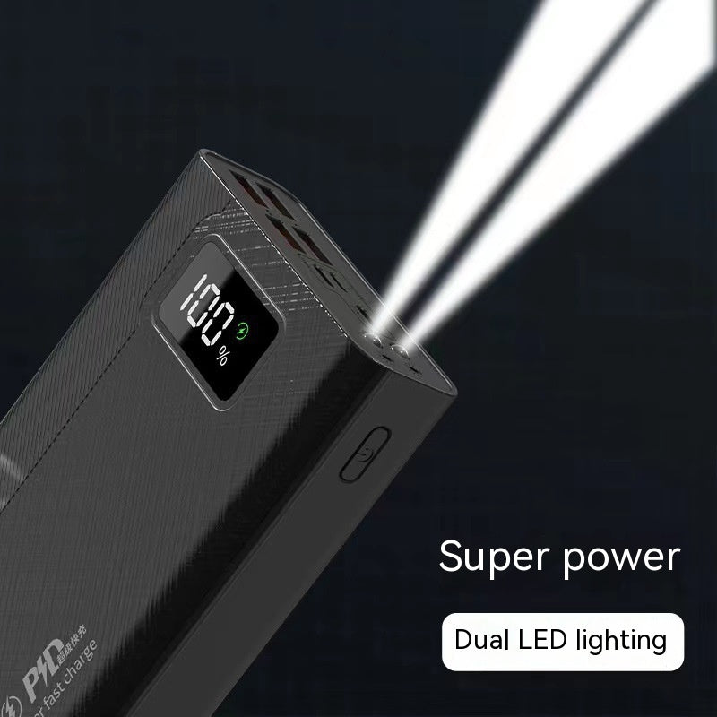 Black textured power bank with a 100% digital display, multiple ports, and an active dual LED flashlight beam.